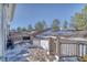 Deck and backyard with retaining walls and snowy landscape at 2959 Skyward Way, Castle Rock, CO 80109