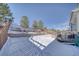 Snowy backyard with a deck and retaining walls at 2959 Skyward Way, Castle Rock, CO 80109