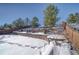 Landscaped backyard with retaining walls and snowy ground at 2959 Skyward Way, Castle Rock, CO 80109