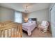 Bedroom with double bed, crib, and rocking chair at 2959 Skyward Way, Castle Rock, CO 80109