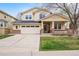 Inviting two-story home featuring a covered porch, brick accents, and a well-manicured lawn at 5049 Heatherglen Dr, Highlands Ranch, CO 80130