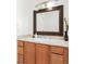 Bathroom vanity features wood cabinets, a large mirror, and neutral countertop at 6891 W Eldorado Pl, Lakewood, CO 80227