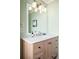 Bathroom vanity features wood cabinets, a large mirror, and neutral countertop at 6891 W Eldorado Pl, Lakewood, CO 80227