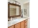 Well-lit bathroom featuring tile countertops, a decorative mirror, and a shower with tiled walls at 6891 W Eldorado Pl, Lakewood, CO 80227