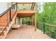 Spacious wooden deck featuring stairs, black railings, and an outdoor lounging area, perfect for relaxation and enjoying the surrounding greenery at 6891 W Eldorado Pl, Lakewood, CO 80227