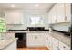 Updated kitchen with granite countertops, black appliances, white cabinets, and a window with natural light at 6891 W Eldorado Pl, Lakewood, CO 80227