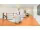 Bright and open living room featuring hardwood floors and modern furnishings; dining room and kitchen visible at 6891 W Eldorado Pl, Lakewood, CO 80227