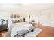 Bright main bedroom with a large bed, modern decor, and hardwood floors at 6891 W Eldorado Pl, Lakewood, CO 80227