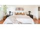 Bright main bedroom with a large bed, modern decor, and hardwood floors at 6891 W Eldorado Pl, Lakewood, CO 80227