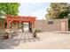 Entrance to a pool area with stone walls, a pergola, and mature plants in pots adorning the entrance at 6891 W Eldorado Pl, Lakewood, CO 80227