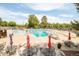 Large outdoor pool with lounge chairs, tables, umbrellas, and landscaping surrounding the pool area at 6891 W Eldorado Pl, Lakewood, CO 80227