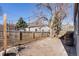 Fenced backyard with a stone patio, barrel accent, and a mature shade tree at 709 2Nd St, Golden, CO 80403