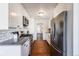Galley kitchen with stainless steel appliances, white cabinets, subway tile backsplash, and hardwood floors at 709 2Nd St, Golden, CO 80403