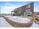 The large backyard features a partially covered patio, snow covered terrace and well maintained fencing at 848 Sandstone Cir, Erie, CO 80516