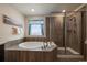 Spa-like bathroom featuring a soaking tub, walk-in shower, and stylish tile work at 848 Sandstone Cir, Erie, CO 80516