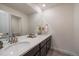 Modern bathroom with double sinks, quartz countertop, and large mirror at 848 Sandstone Cir, Erie, CO 80516