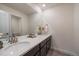 Modern bathroom boasts double sinks, quartz countertops, and sleek, dark wood cabinetry at 848 Sandstone Cir, Erie, CO 80516