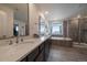 Well-lit bathroom with a double sink vanity, soaking tub, and a glass enclosed shower at 848 Sandstone Cir, Erie, CO 80516