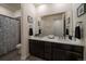 Bathroom with double sink vanity, granite countertops, and decorative shower curtain at 848 Sandstone Cir, Erie, CO 80516