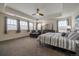 Spacious bedroom with tray ceiling, multiple windows, chaise lounge and a ceiling fan at 848 Sandstone Cir, Erie, CO 80516