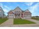 Charming two-story home featuring a manicured lawn and two-car garages, perfect for families at 848 Sandstone Cir, Erie, CO 80516