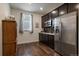 Kitchen area features stainless steel appliances, dark cabinetry, and hardwood floors with natural light at 848 Sandstone Cir, Erie, CO 80516