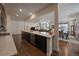 Open kitchen layout with sleek countertops, stainless steel appliances, and a view of the living area at 848 Sandstone Cir, Erie, CO 80516