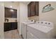 Well-organized laundry room with cabinetry, a utility sink, and modern washer and dryer at 848 Sandstone Cir, Erie, CO 80516