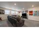 Finished basement rec room with plush sectional couch, movie posters and plenty of light from the garden-level windows at 848 Sandstone Cir, Erie, CO 80516