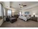 Comfortable bedroom with a seating area, tray ceiling, and a soft, neutral color scheme at 848 Sandstone Cir, Erie, CO 80516