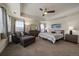 Large primary suite with tray ceiling, sitting area, fan, and plenty of natural light at 848 Sandstone Cir, Erie, CO 80516