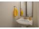 Traditional powder room with pedestal sink, yellow towel, and framed mirror at 848 Sandstone Cir, Erie, CO 80516