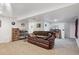Basement living area featuring a comfortable leather couch, shelving, and decor at 11337 E 1St Ave, Aurora, CO 80010