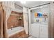 Bathroom with a soaking tub, shower and laundry area with washer and dryer at 11337 E 1St Ave, Aurora, CO 80010