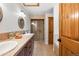 Bathroom featuring dual sinks, custom cabinetry, tiled countertops, walk-in shower and separate bathtub at 4525 King St, Denver, CO 80211