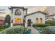 Stunning two-story house with beautiful curb appeal, arched windows, and lush green landscaping at 4525 King St, Denver, CO 80211