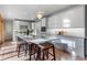 Open kitchen featuring a large marble island with seating, stainless appliances, and white cabinetry at 4525 King St, Denver, CO 80211