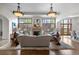 Bright living room with large windows, stone fireplace, hardwood floors, and stylish chandeliers at 4525 King St, Denver, CO 80211