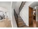 Staircase featuring decorative tiling, dark iron railing, and hardwood floors at 4525 King St, Denver, CO 80211