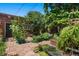 Lush backyard garden with various plants and flowers, brick walkway, and charming back entrance at 1243 N Lafayette St, Denver, CO 80218