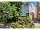 Enchanting backyard oasis with a deck, garden beds, mature trees, and charming outdoor seating at 1243 N Lafayette St, Denver, CO 80218