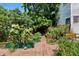 Spacious backyard featuring garden beds, brick pathways, mature trees, and access to a wooden deck at 1243 N Lafayette St, Denver, CO 80218