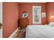 Bright bedroom featuring orange walls, vintage dresser, and natural light at 1243 N Lafayette St, Denver, CO 80218