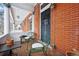 Charming front porch with green chairs, potted plants, and brick exterior at 1243 N Lafayette St, Denver, CO 80218