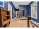 Bright hallway with hardwood floors, a mirror, and blue walls showcasing artwork and stylish decor at 1243 N Lafayette St, Denver, CO 80218