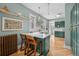 Updated kitchen with white countertops, stylish bar stools, and green cabinets flowing into the dining area at 1243 N Lafayette St, Denver, CO 80218