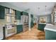 Spacious kitchen featuring stainless steel appliances, green cabinetry, and a functional layout perfect for cooking at 1243 N Lafayette St, Denver, CO 80218