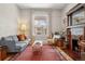 Inviting living room featuring a decorative fireplace, hardwood floors, and abundant natural light from large windows at 1243 N Lafayette St, Denver, CO 80218