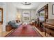 Spacious living room with a fireplace, piano, and ample seating, illuminated by natural light from a large window at 1243 N Lafayette St, Denver, CO 80218