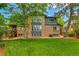 Home exterior with a lush green lawn, trees, and deck with stairs at 11209 Quivas Loop, Denver, CO 80234